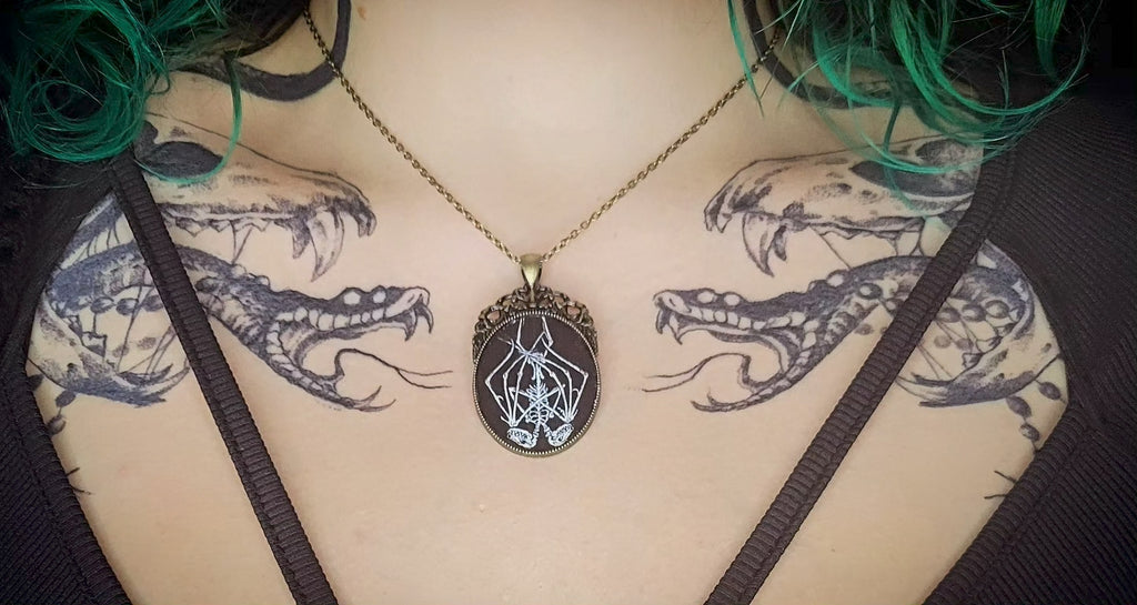 Handmade gothic necklace — hand-painted bat sigil, oval pendant with metal frame and chain, varnish finish