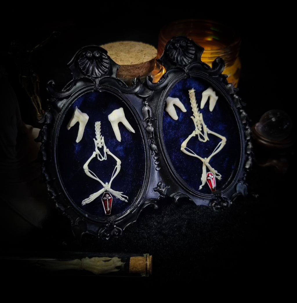 Decorative item with skeleton design and red accents on a dark background Handmade gothic twin frame with mirrored mouse skeletons on dark blue velvet, baroque double frame