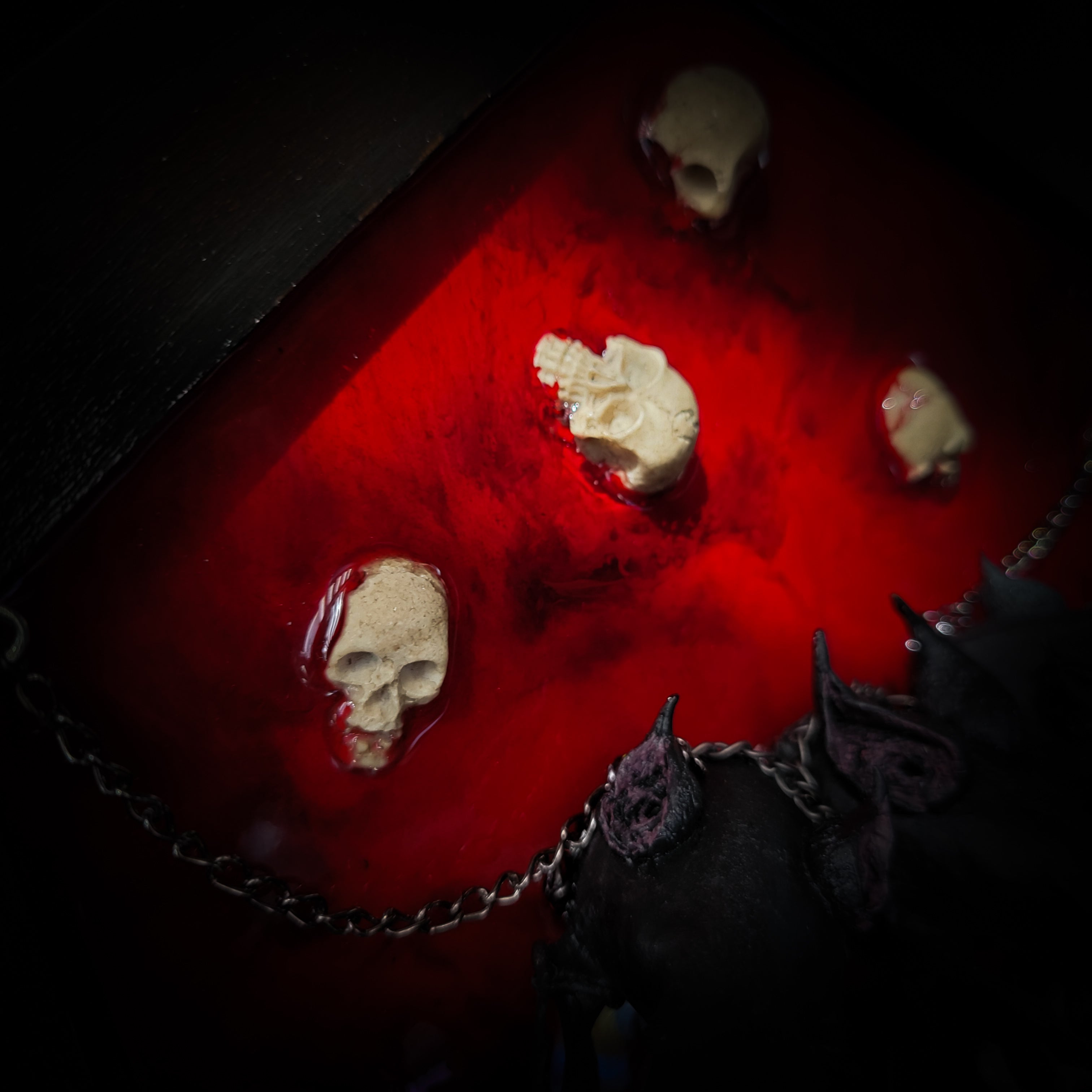 Cerberus | Collectors Work — handmade gothic wall decor with three real mink skulls, sculpted ears and tongues, decorative chains, silver crow ornaments and Latin inscription plaque on deep red velvet, hexagon frame, 23x27cm