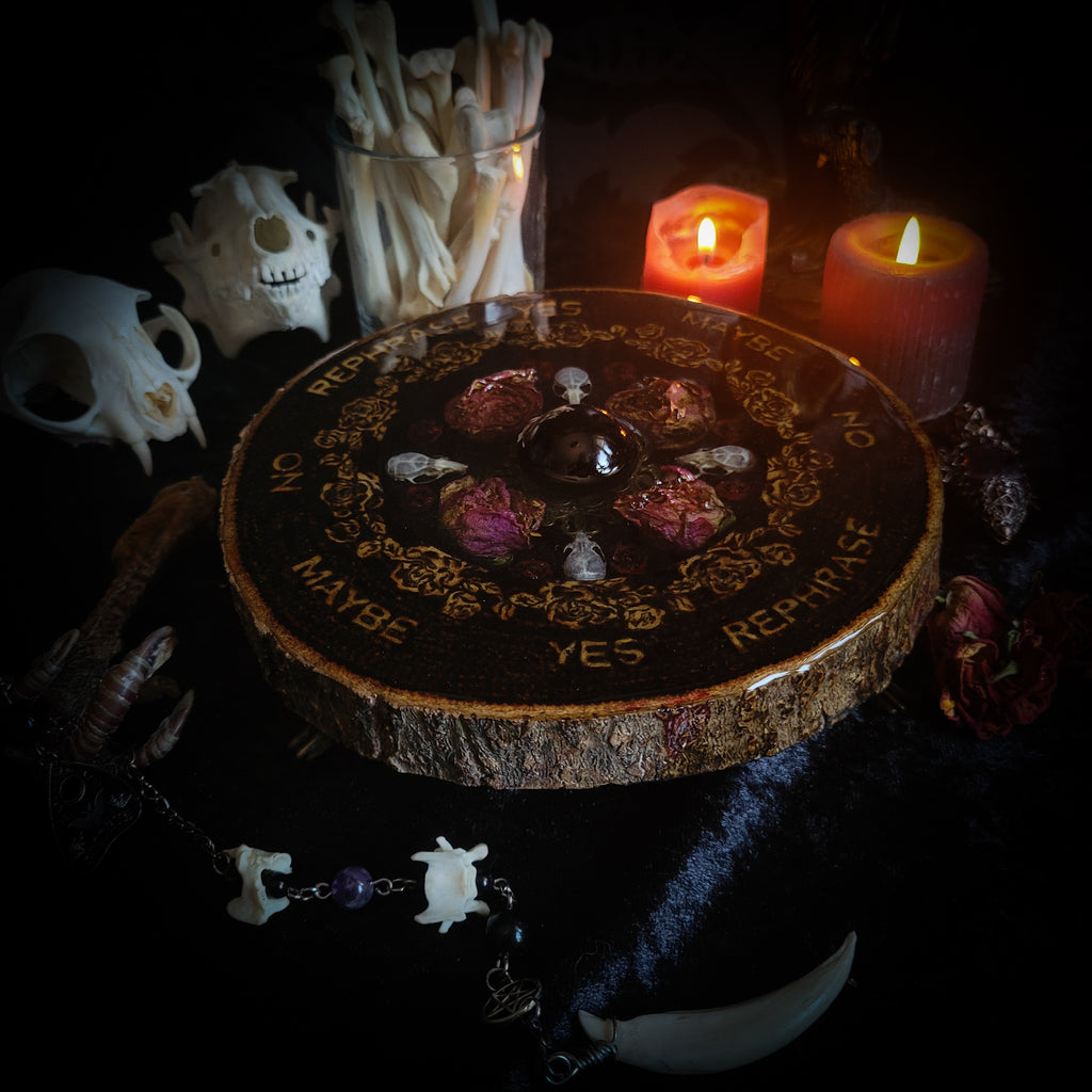 Wooden Pendulum Board — handmade divination pendulum board, made to order. Natural wood slice with hand-burned pyrography design, resin roses, crystals and ornamented legs. Custom witchcraft tool and altar decor by Morbid Oddities.