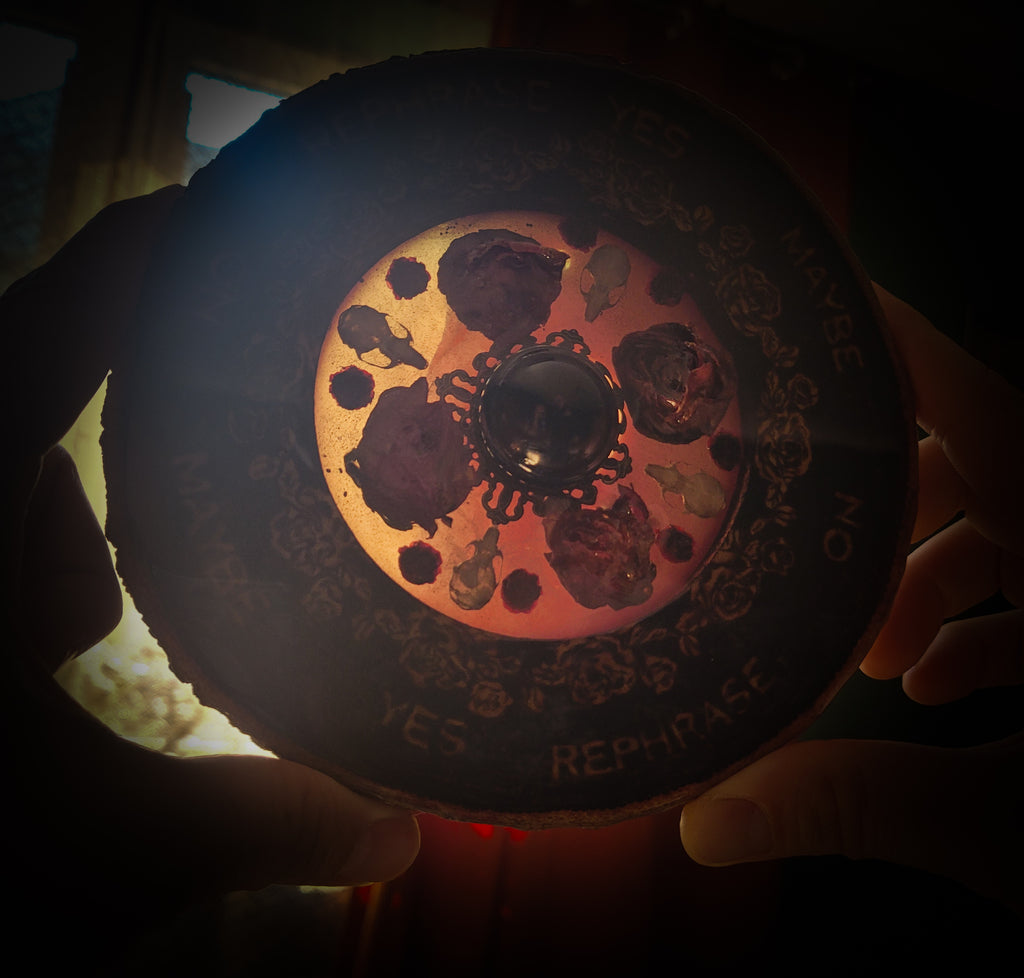Wooden Pendulum Board — handmade divination pendulum board, made to order. Natural wood slice with hand-burned pyrography design, resin roses, crystals and ornamented legs. Custom witchcraft tool and altar decor by Morbid Oddities.