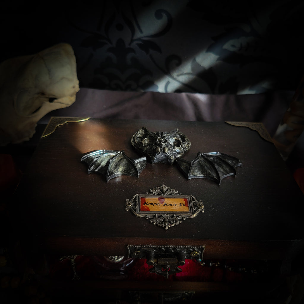 Vampire Hunter Kit — handmade gothic relic box, made to order. Hand-painted ornamented wooden suitcase with vampire stake, hammer, holy water, rosaries, crucifix, glass vials, miniature Bible and crimson velvet lining. Dark collectible decor, 23x17x9.5cm.