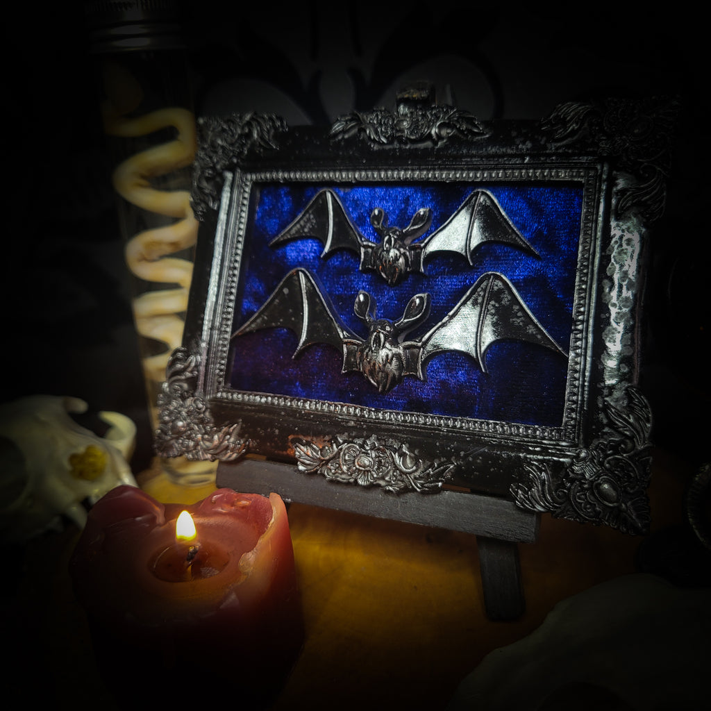 Nox Caelestis — handmade gothic shadowbox, made to order. Detailed handcrafted bat set in ornate decorative frame on deep blue velvet background. Nocturnal gothic wall decor, 12x9.5cm.