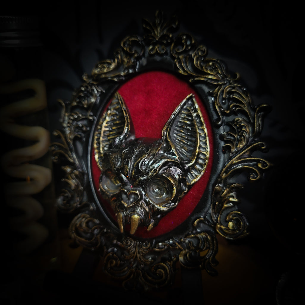 Handmade gothic wall frame featuring a detailed bat centerpiece set on deep blood-red velvet, enclosed in an ornate baroque-style frame. Dramatic, ritual-inspired made-to-order piece with rich crimson velvet and dark gothic aesthetic, 12.5x10cm | Morbid Oddities