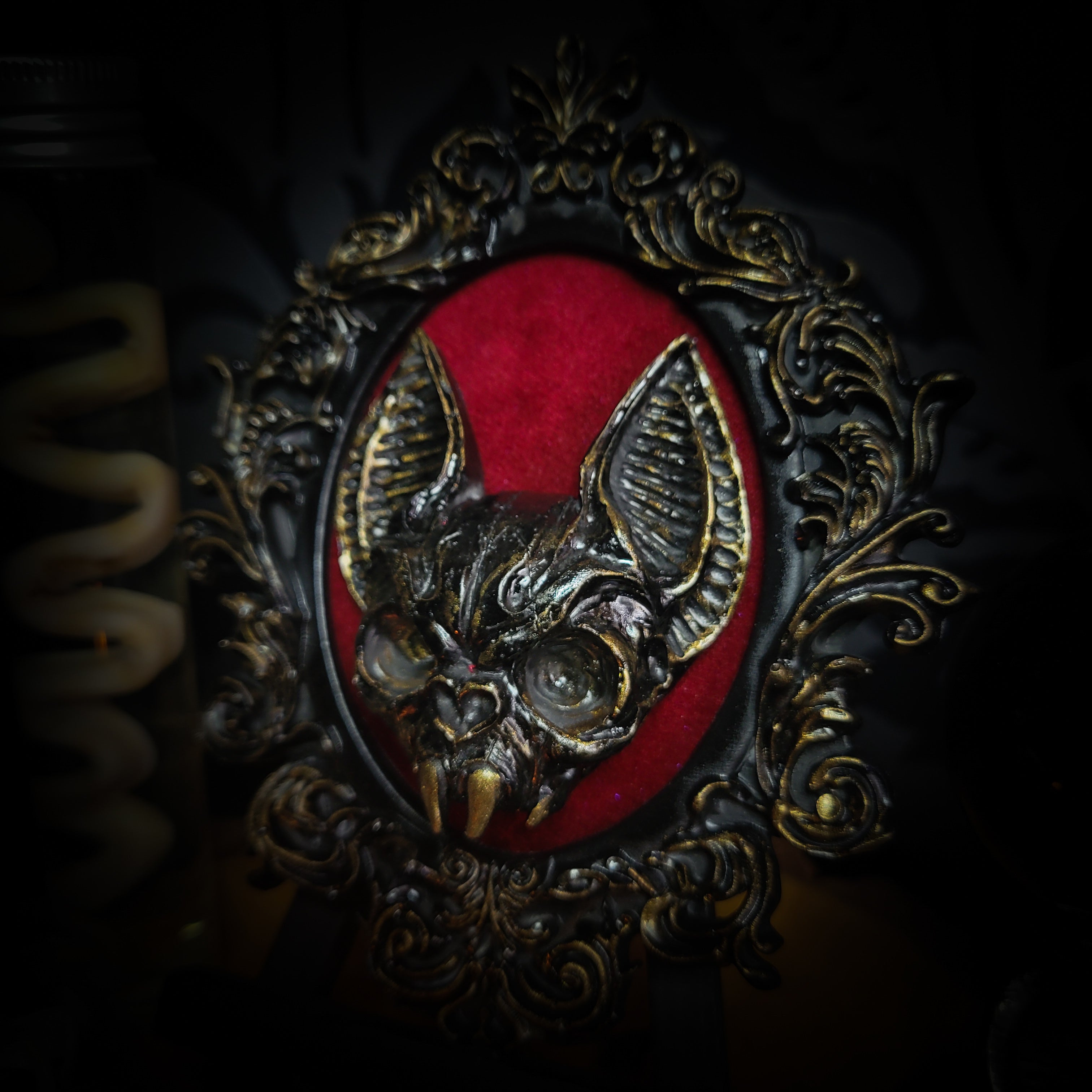 Handmade gothic wall frame featuring a detailed bat centerpiece set on deep blood-red velvet, enclosed in an ornate baroque-style frame. Dramatic, ritual-inspired made-to-order piece with rich crimson velvet and dark gothic aesthetic, 12.5x10cm | Morbid Oddities