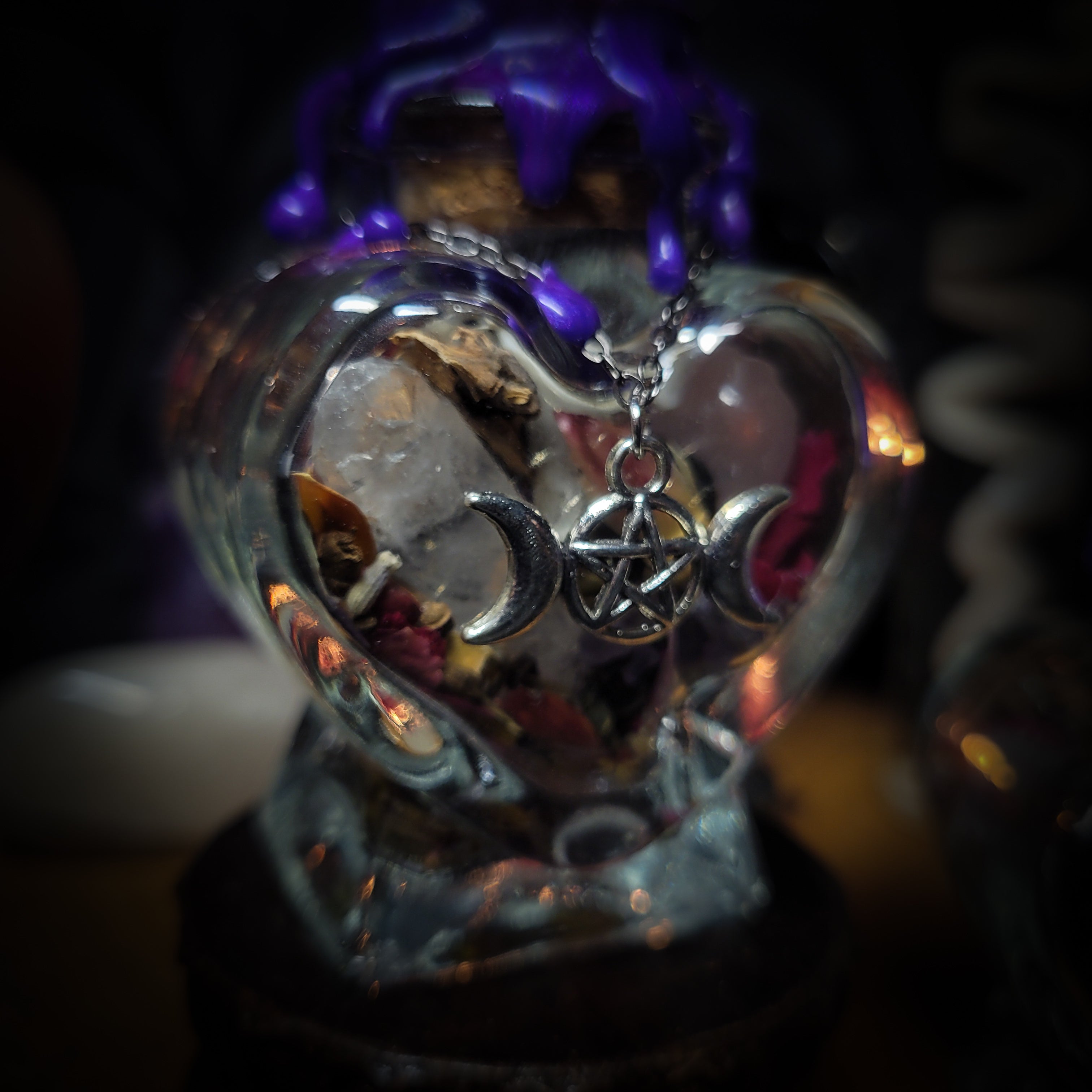 Handmade gothic twin spell jar set — two heart-shaped glass vessels sealed with violet wax and amethyst moon, filled with herbs, crystals and bones for love binding ritual