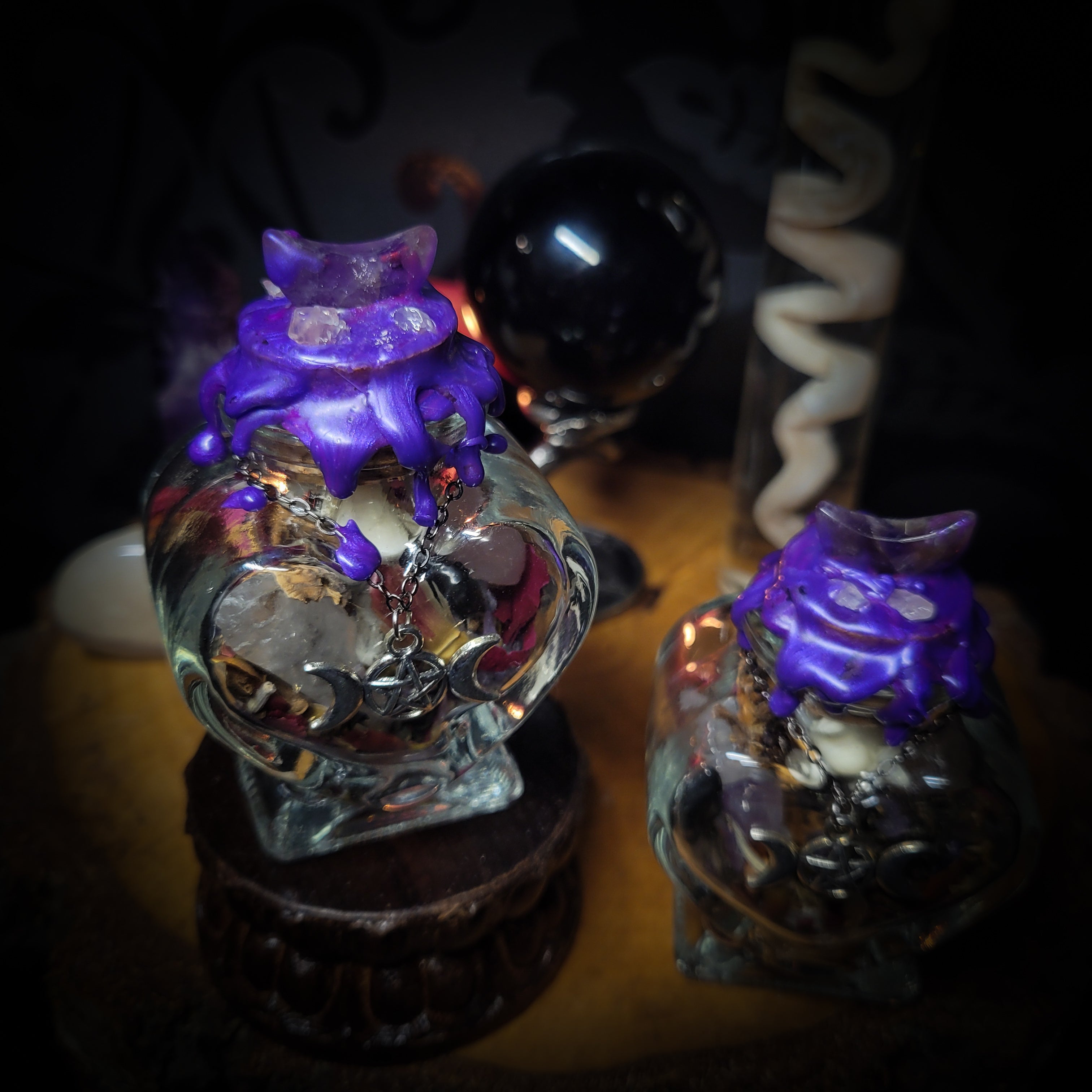 Handmade gothic twin spell jar set — two heart-shaped glass vessels sealed with violet wax and amethyst moon, filled with herbs, crystals and bones for love binding ritual