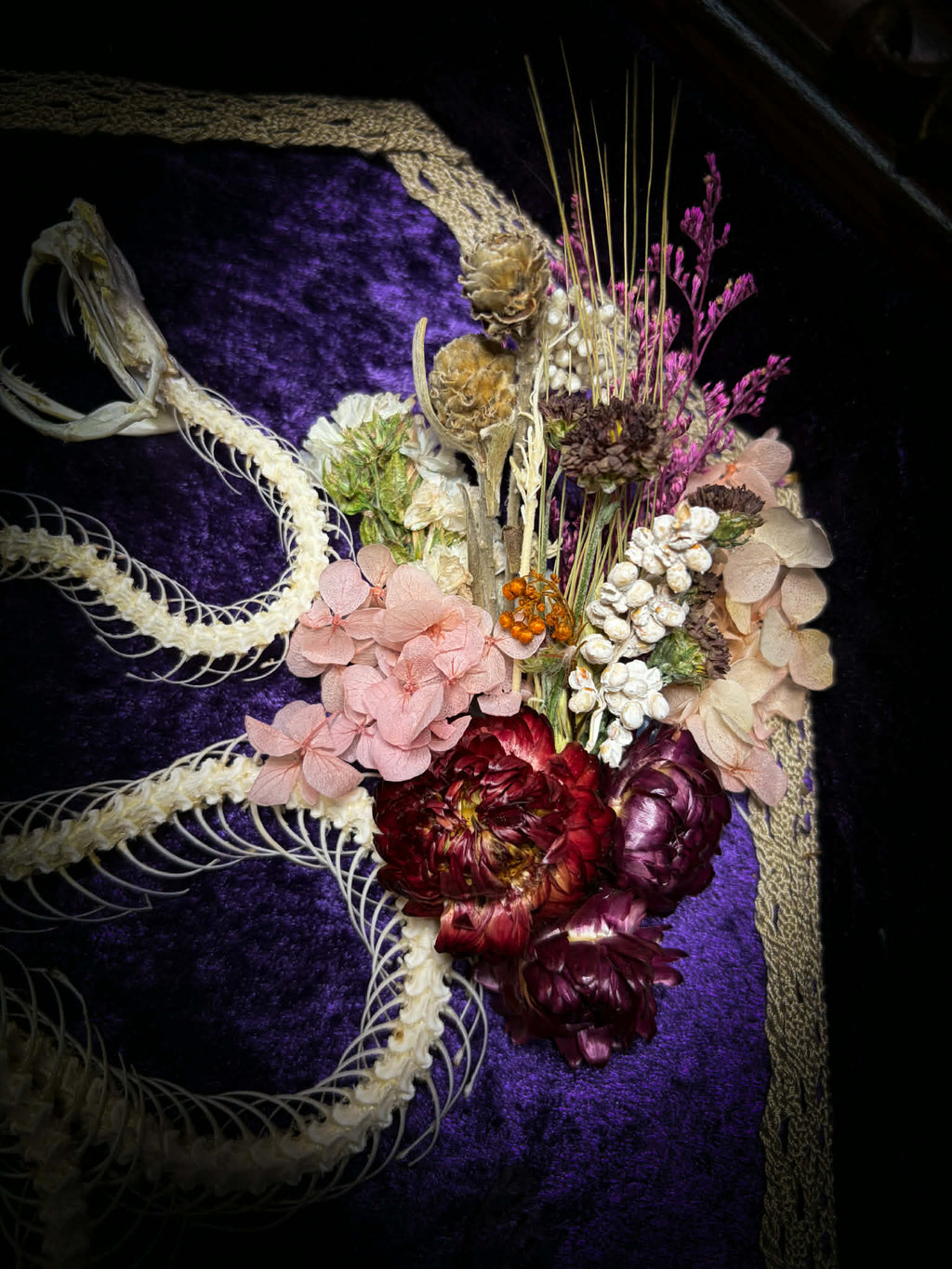 Gothic shadowbox — articulated snake skeleton on deep violet velvet, preserved florals, ghost cicadas, baroque wooden frame with gold accents, 45x35cm