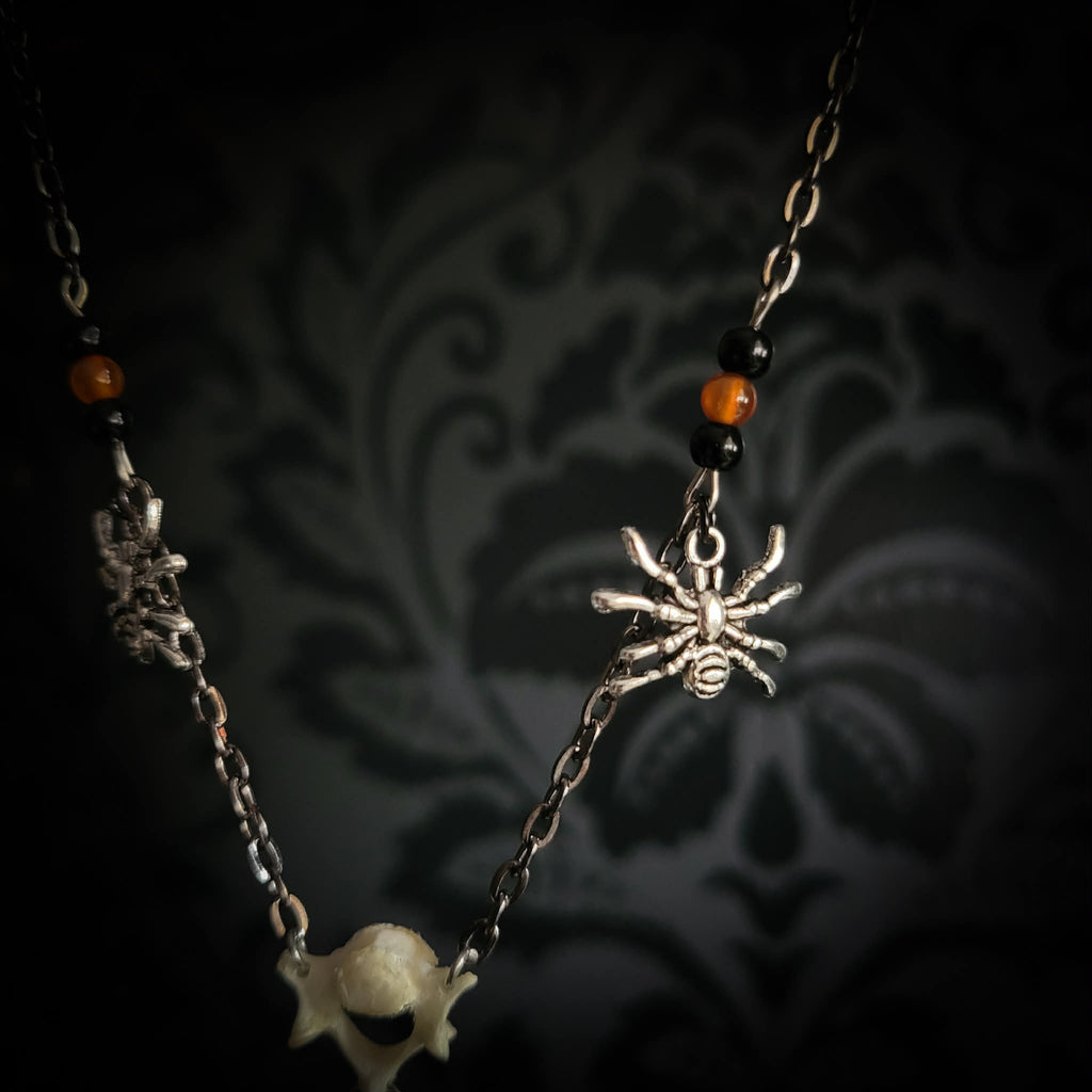 Handmade gothic necklace — tiger's eye stone and mouse jaw in resin pendant, snake skin background, vertebrae connector, metal spiders, carnelian beads