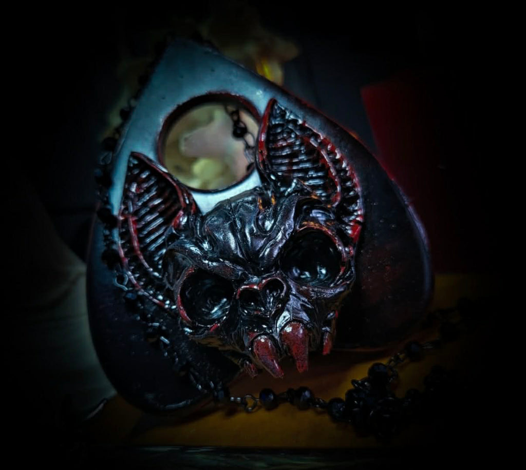 Ouija Planchette — handmade gothic planchette sculpture, made to order. Hand-cast bat and demonic face centerpiece in classic planchette shape, dark bloody finish with deep red accents. Occult altar decor, 8x9cm.