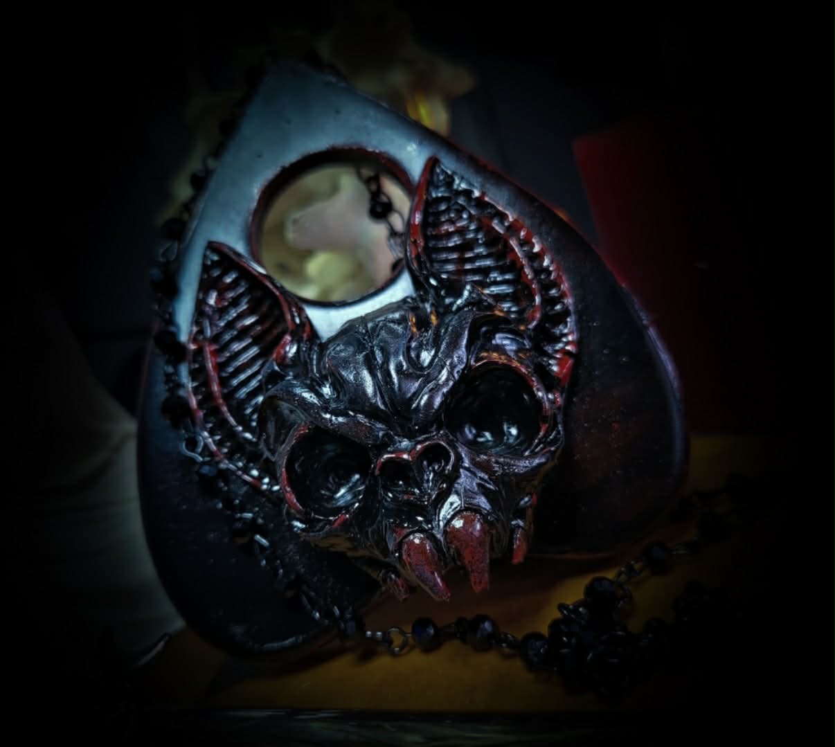 Ouija Planchette — handmade gothic planchette sculpture, made to order. Hand-cast bat and demonic face centerpiece in classic planchette shape, dark bloody finish with deep red accents. Occult altar decor, 8x9cm.