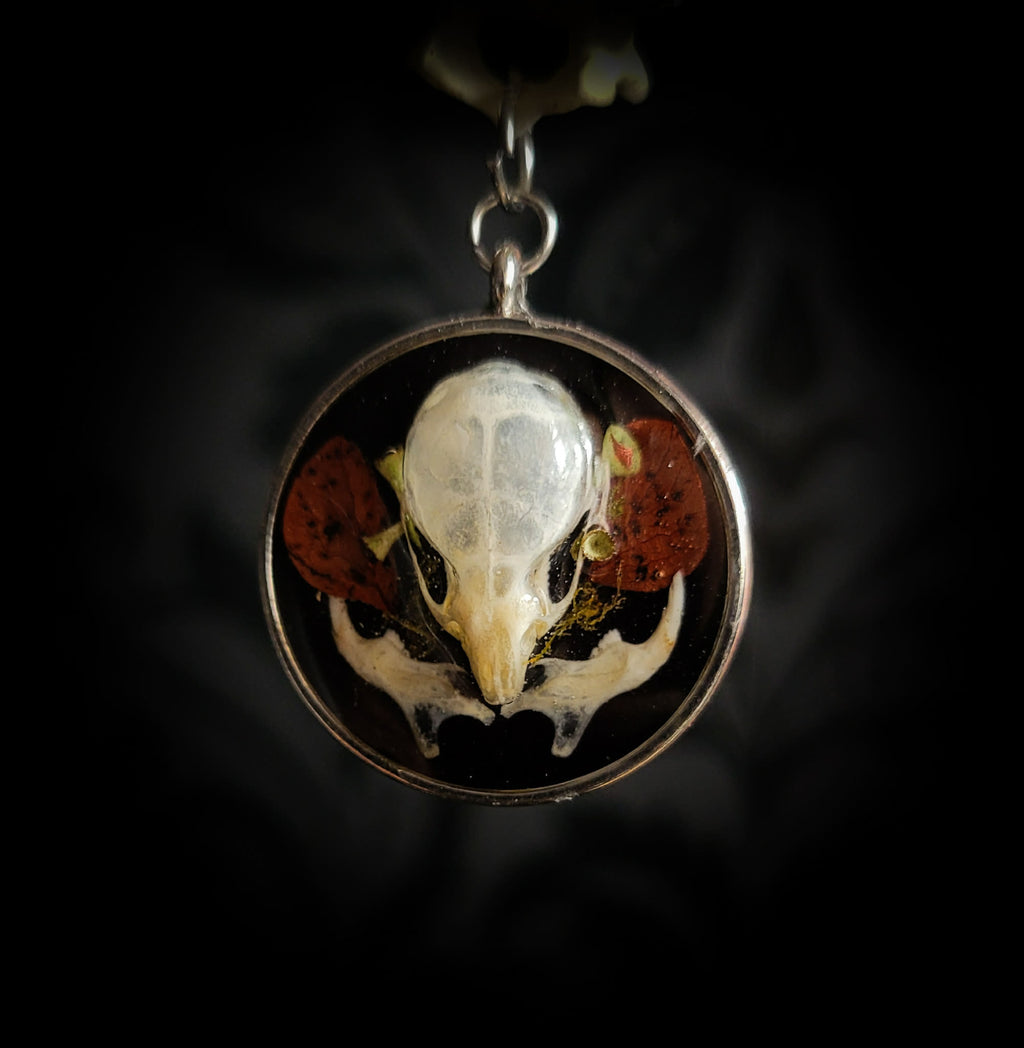 Handmade gothic necklace — real mouse skull in circular resin pendant, dried red petals, triple moon pentagram charm, garnet beads