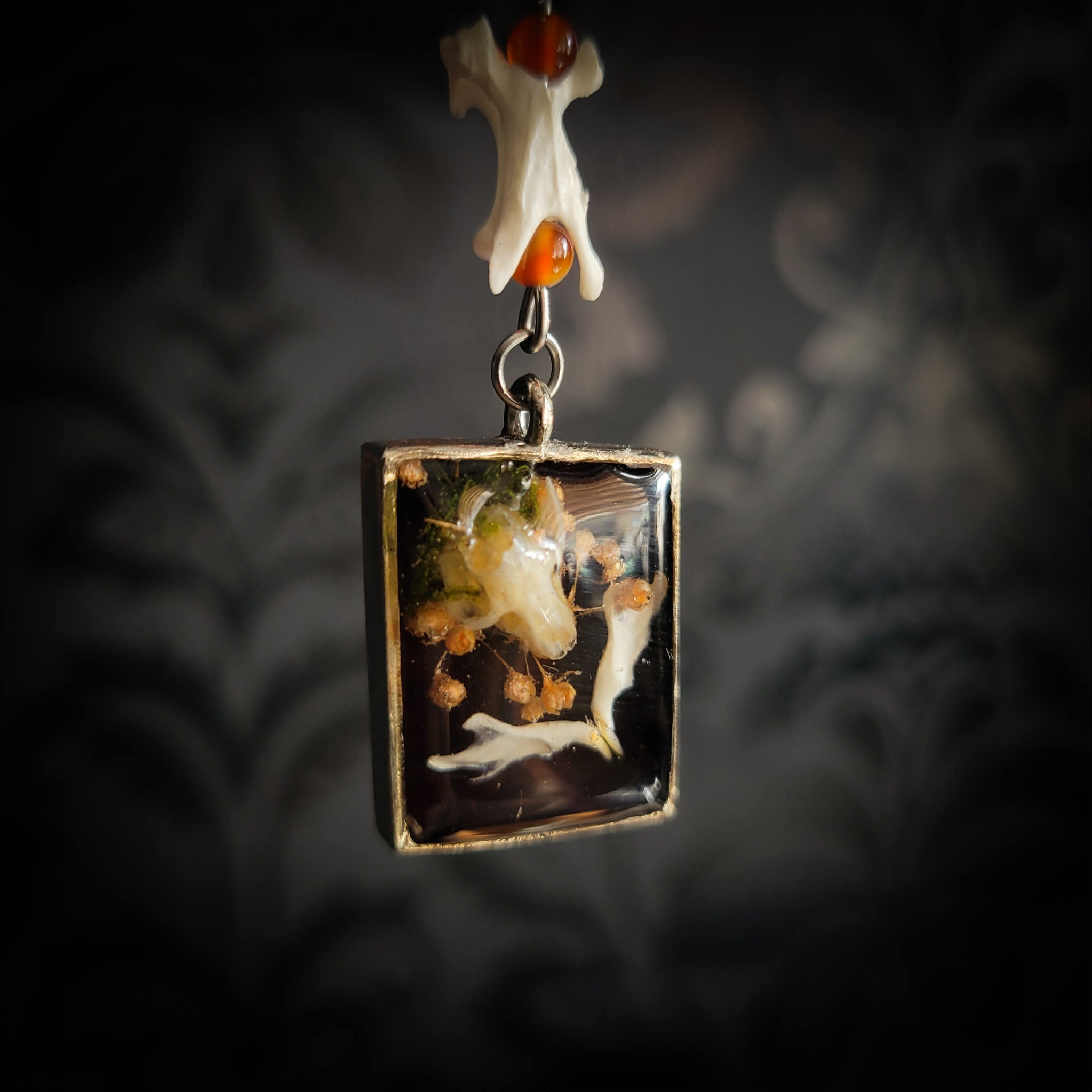 Handmade gothic necklace — mouse skull and jaw with dried flowers in hexagonal resin pendant, vertebrae connector, metal bat charm, carnelian beads