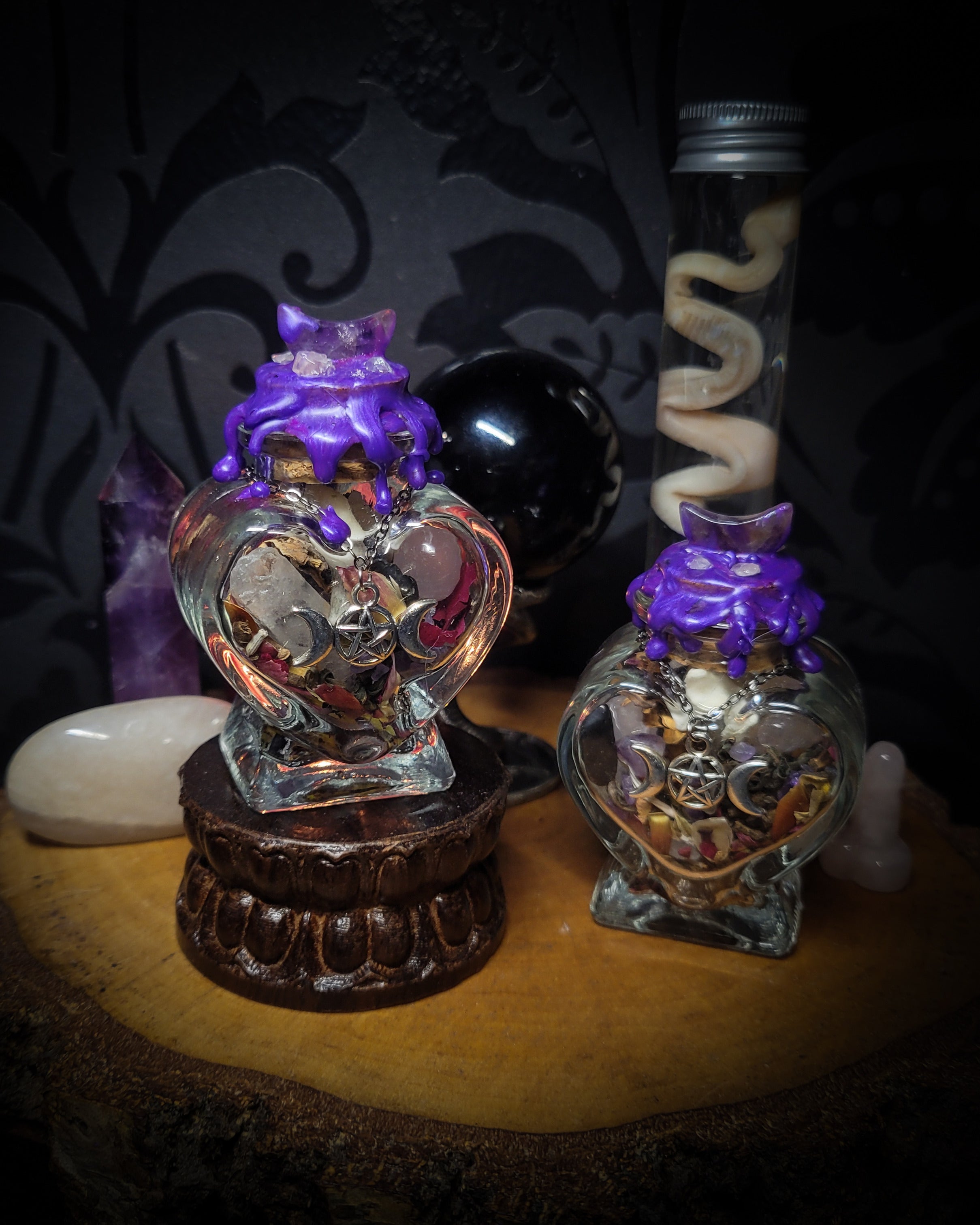 Handmade gothic twin spell jar set — two heart-shaped glass vessels sealed with violet wax and amethyst moon, filled with herbs, crystals and bones for love binding ritual