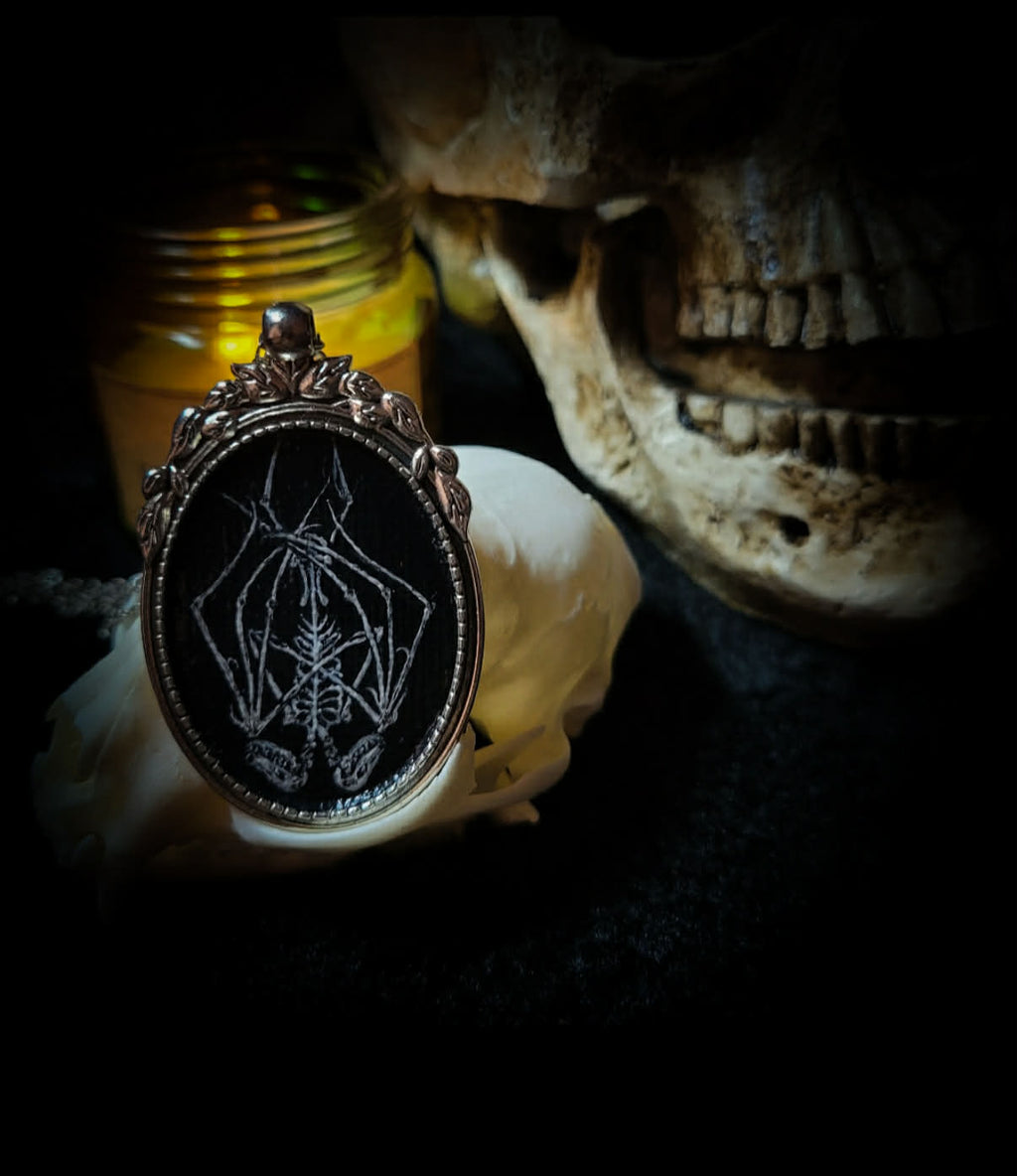 Handmade gothic necklace — hand-painted bat sigil, oval pendant with metal frame and chain, varnish finish