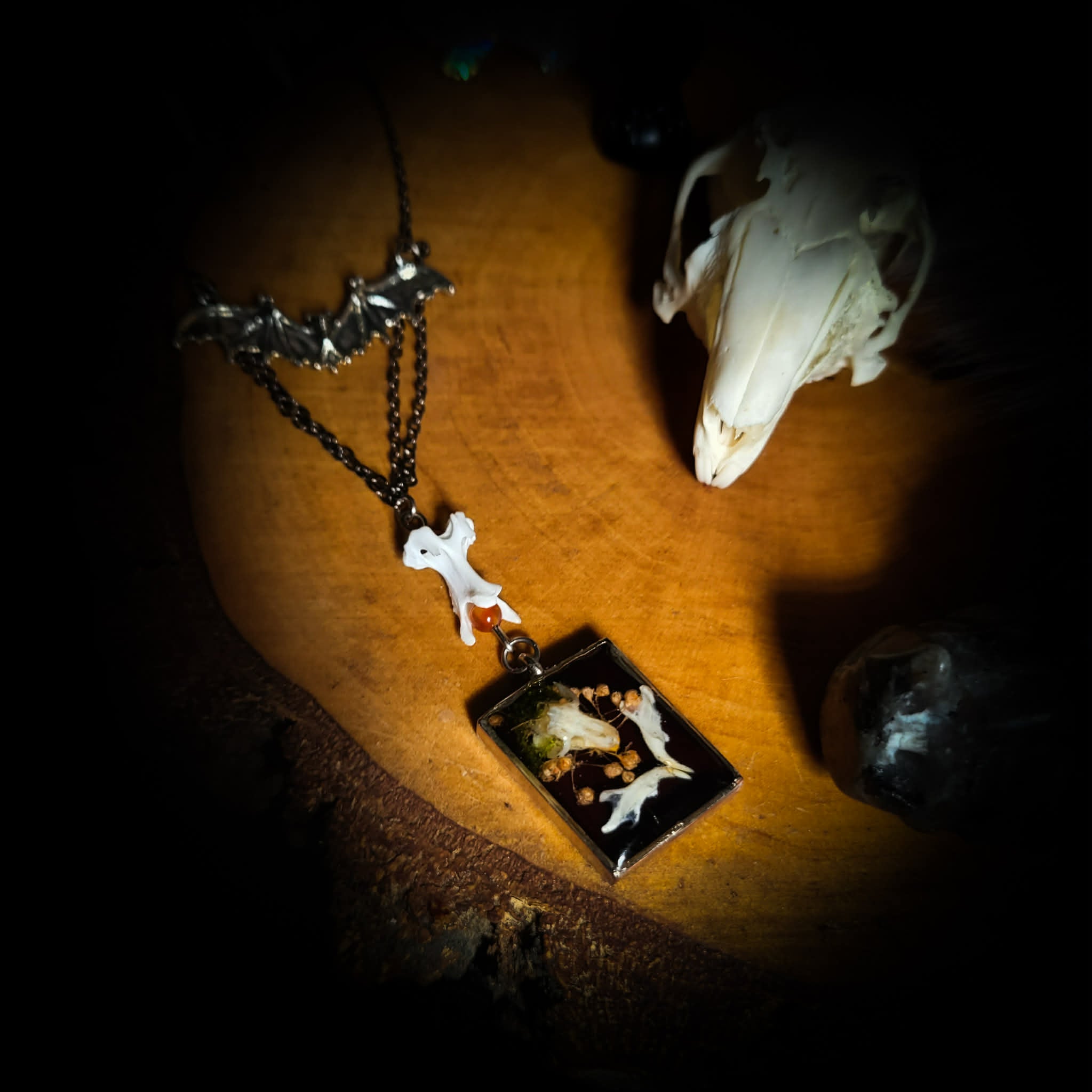 Handmade gothic necklace — mouse skull and jaw with dried flowers in hexagonal resin pendant, vertebrae connector, metal bat charm, carnelian beads