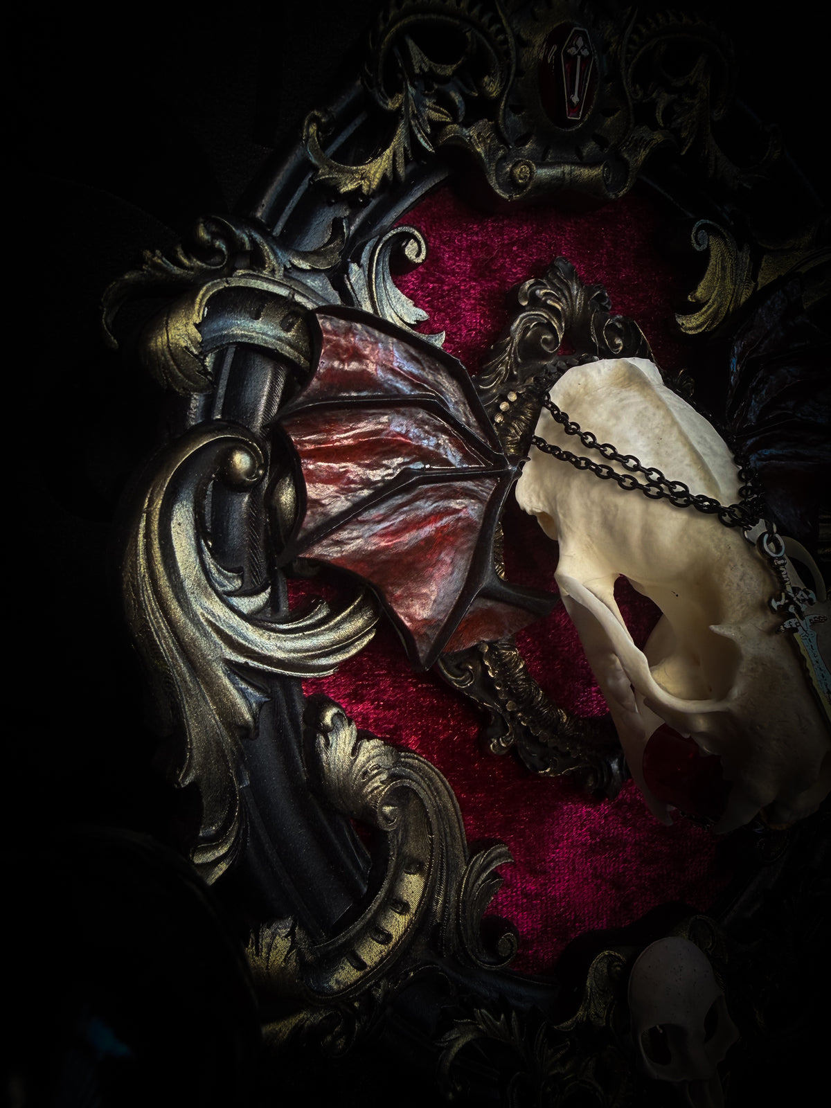 Handmade gothic wall decor with real mink skull, hand-cast bat wings, red velvet and gold frame — Malachar by Morbid Oddities