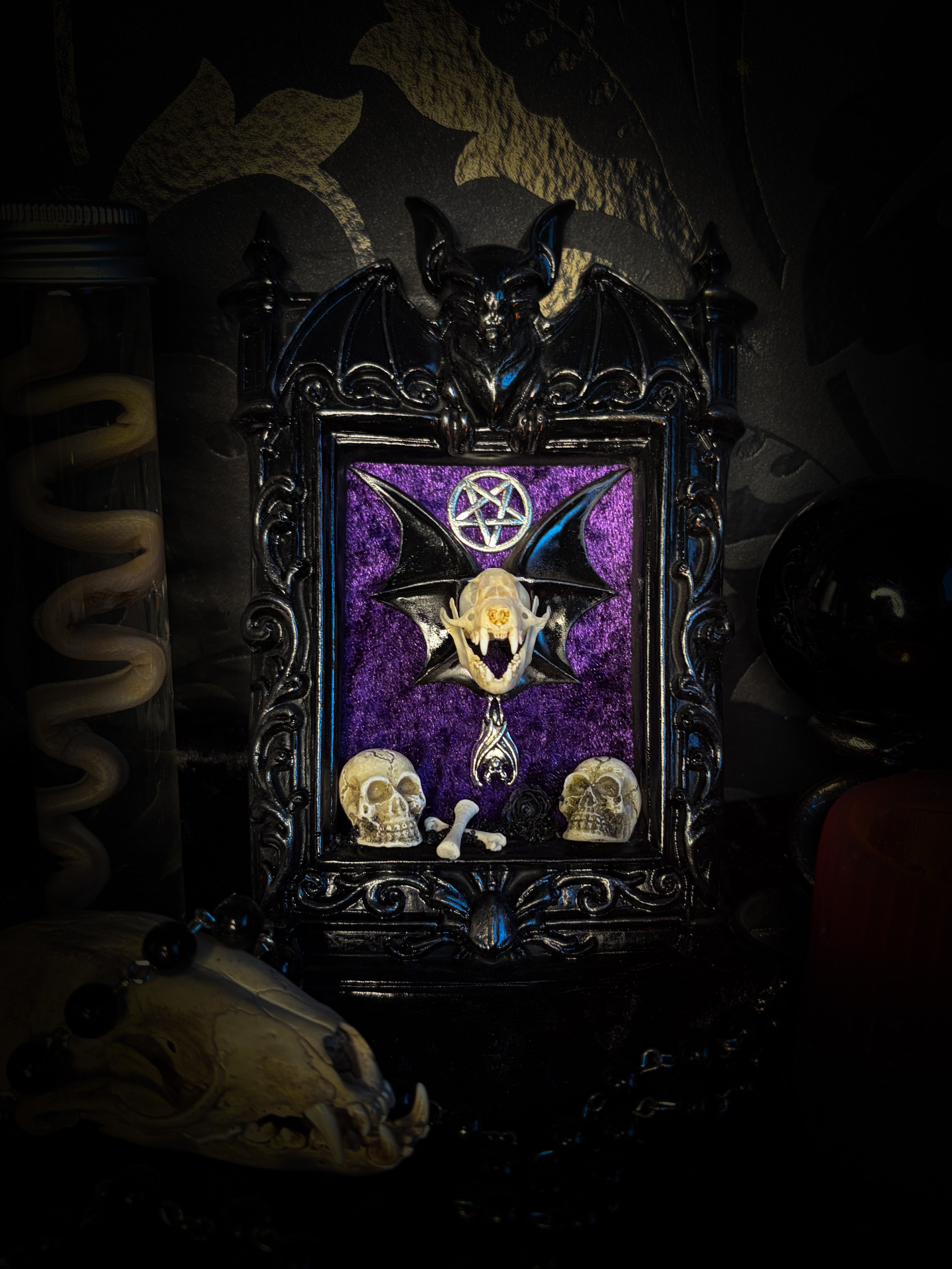Violet Hex — handmade gothic wall relic, ready to ship. Real bat skull with hand-cast wings on violet crushed velvet in black and gold frame with sculpted bat, ornamental skulls, wax rose and pentagram details. One-of-a-kind dark decor, 16x11cm.