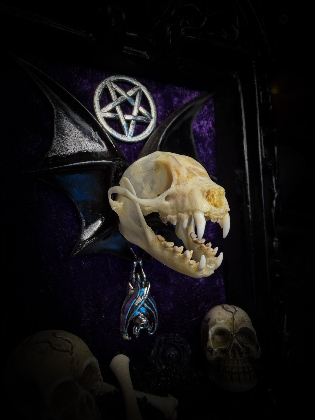 Violet Hex — handmade gothic wall relic, ready to ship. Real bat skull with hand-cast wings on violet crushed velvet in black and gold frame with sculpted bat, ornamental skulls, wax rose and pentagram details. One-of-a-kind dark decor, 16x11cm.