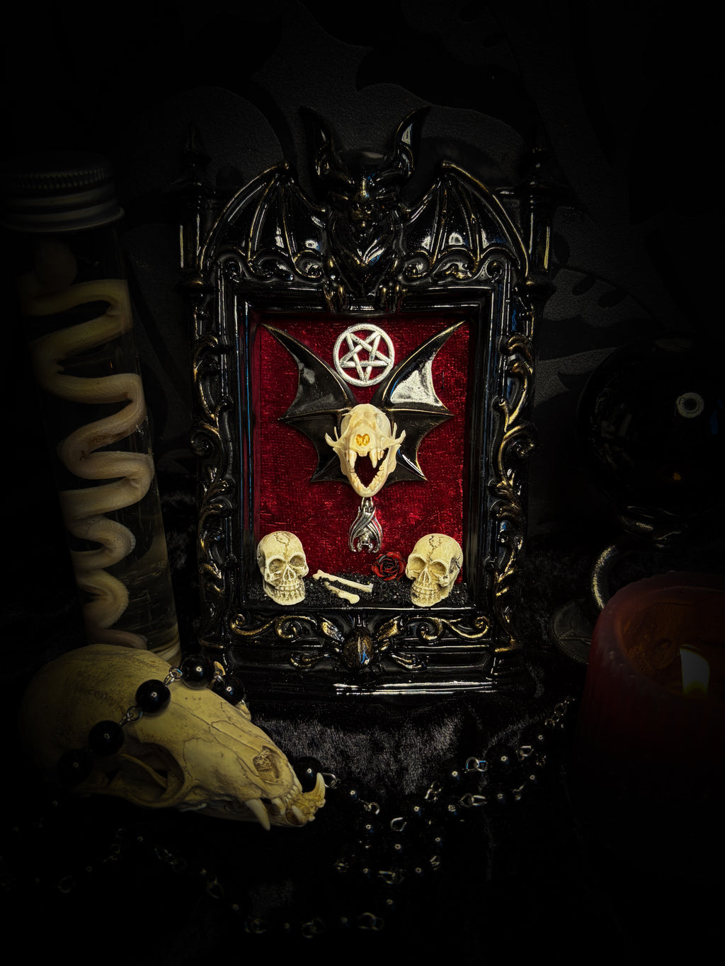 Crimson Ritual — handmade gothic wall relic, ready to ship. Real bat skull with hand-cast wings on crimson crushed velvet in black and gold frame with sculpted bat, ornamental skulls, wax rose and pentagram details. One-of-a-kind dark decor, 16x11cm.