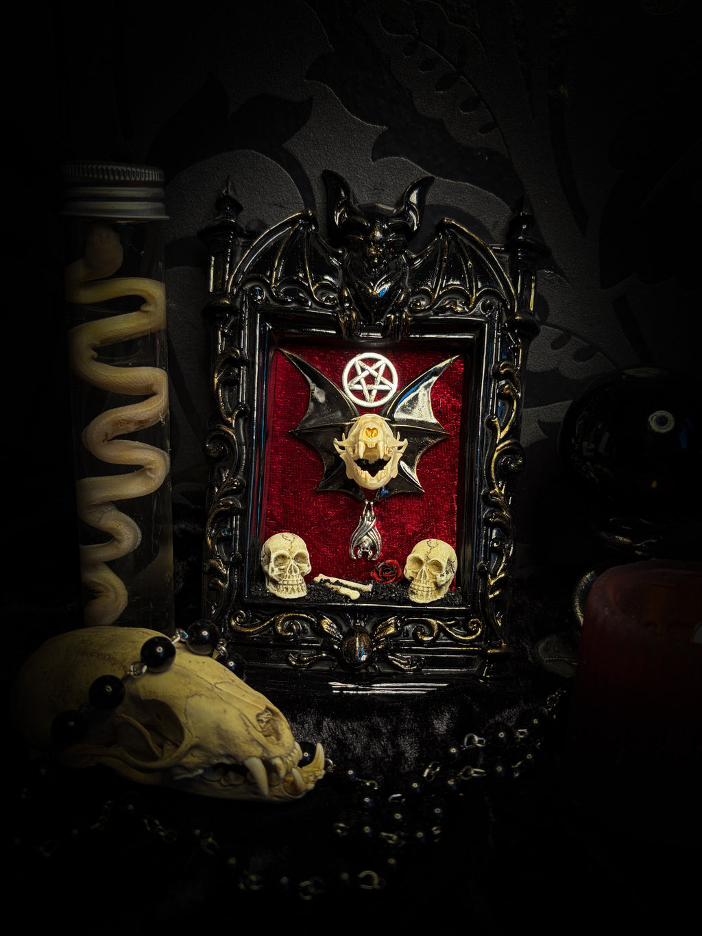Crimson Ritual — handmade gothic wall relic, ready to ship. Real bat skull with hand-cast wings on crimson crushed velvet in black and gold frame with sculpted bat, ornamental skulls, wax rose and pentagram details. One-of-a-kind dark decor, 16x11cm.