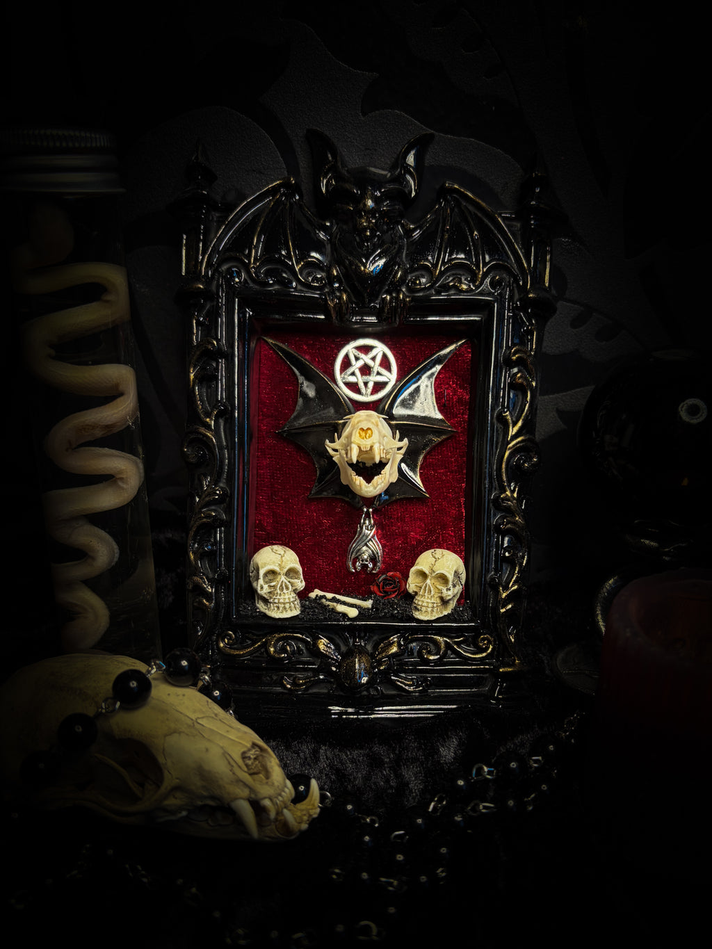 Crimson Ritual — handmade gothic wall relic, ready to ship. Real bat skull with hand-cast wings on crimson crushed velvet in black and gold frame with sculpted bat, ornamental skulls, wax rose and pentagram details. One-of-a-kind dark decor, 16x11cm.