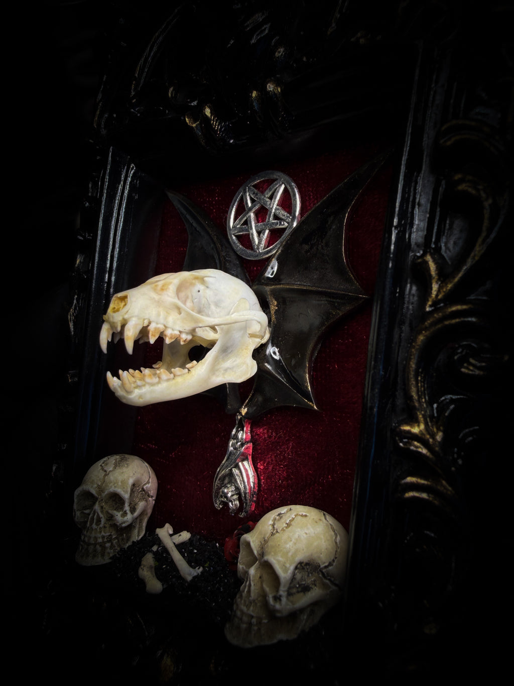 Crimson Ritual — handmade gothic wall relic, ready to ship. Real bat skull with hand-cast wings on crimson crushed velvet in black and gold frame with sculpted bat, ornamental skulls, wax rose and pentagram details. One-of-a-kind dark decor, 16x11cm.