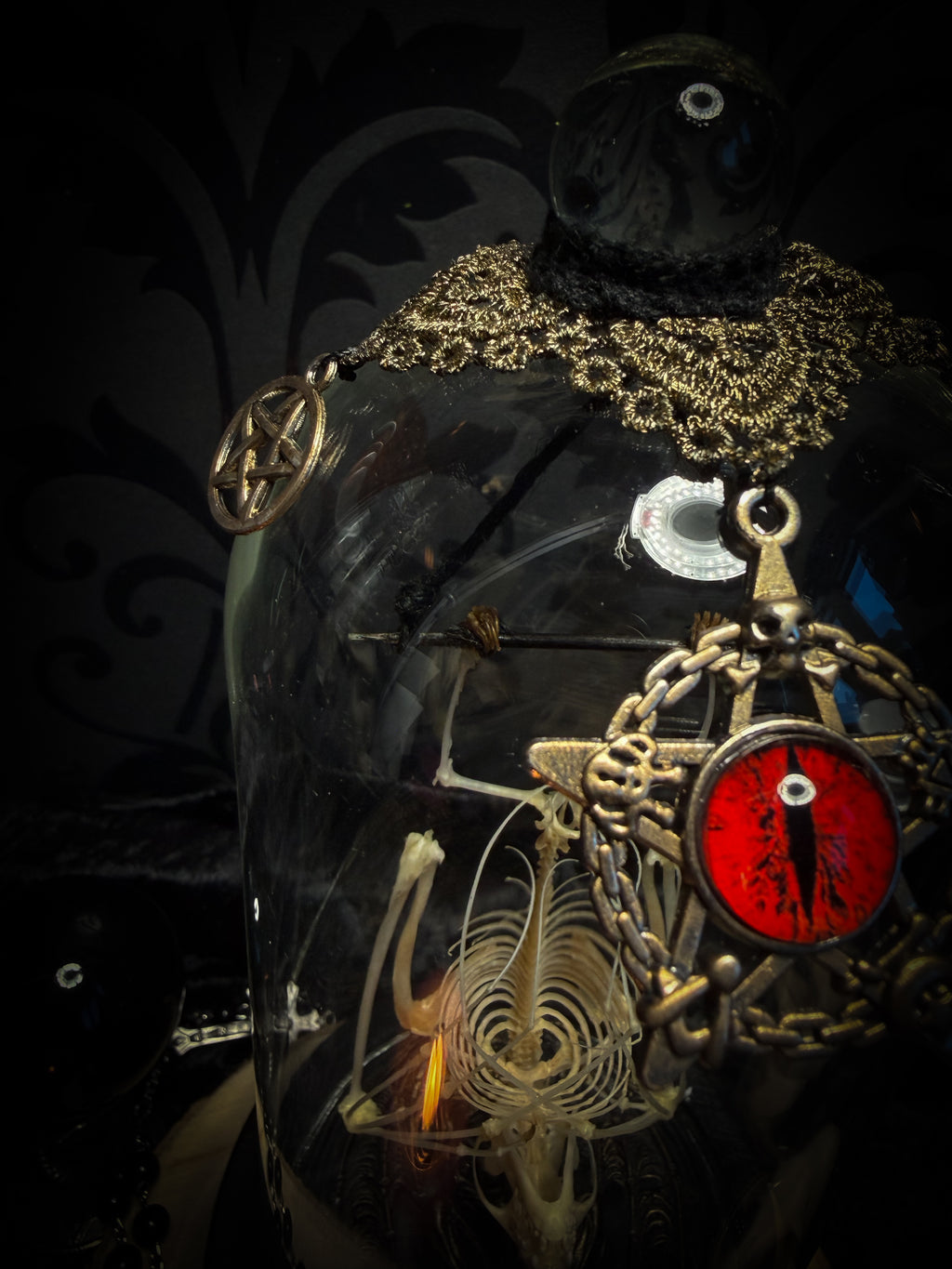 Fangtasia — handmade gothic glass dome display, ready to ship. Suspended bat skeleton under glass cloche with ornate sigil pendant, red glass eye and Latin inscription plaque, aged finish. One-of-a-kind occult decor, 12x24cm.