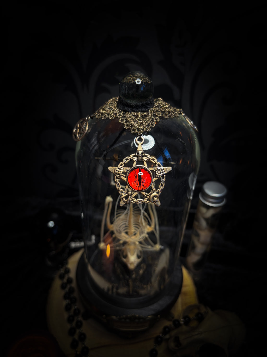 Fangtasia — handmade gothic glass dome display, ready to ship. Suspended bat skeleton under glass cloche with ornate sigil pendant, red glass eye and Latin inscription plaque, aged finish. One-of-a-kind occult decor, 12x24cm.