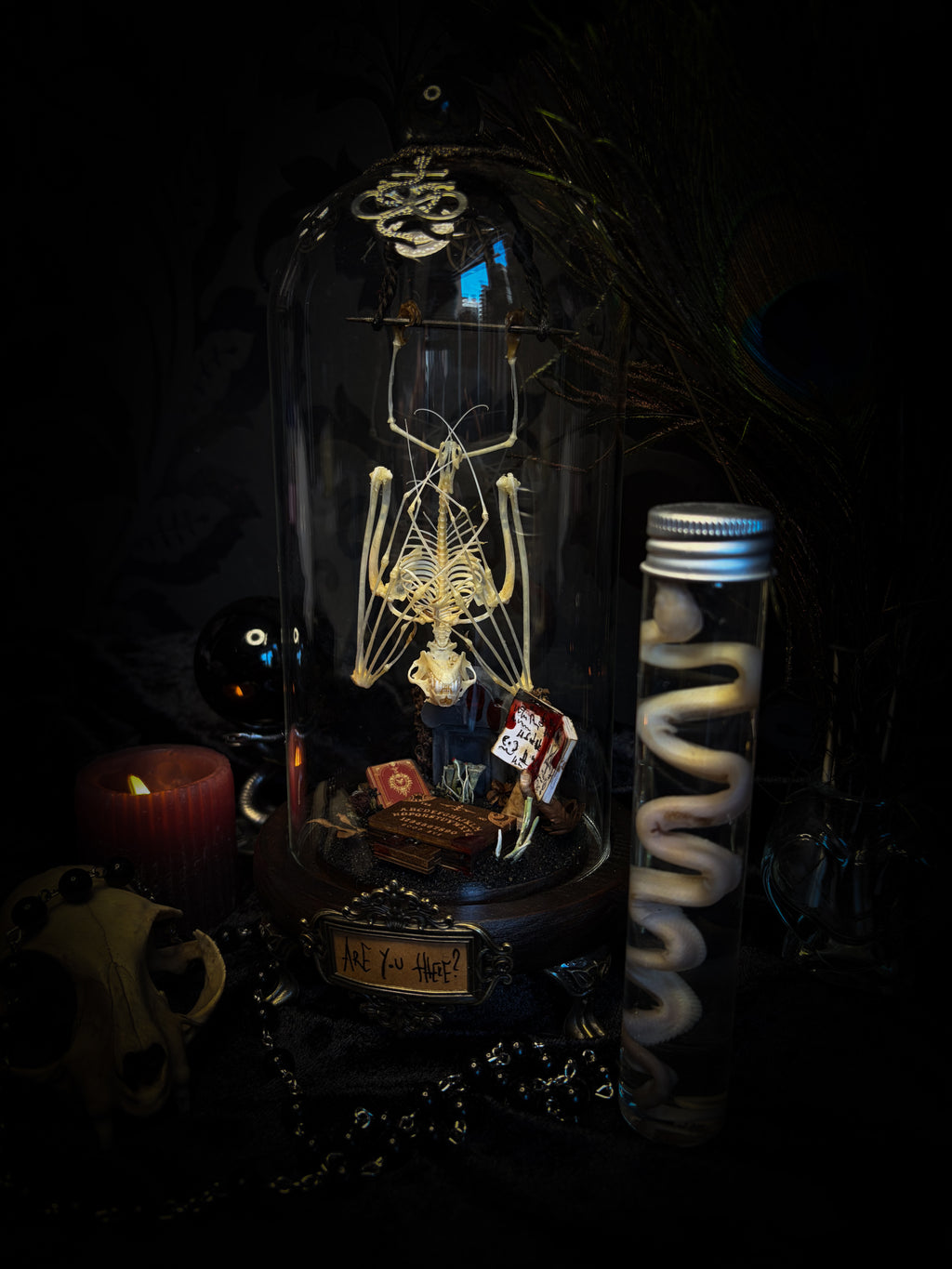 Handmade gothic occult display — bat skeleton in glass dome with Leviathan sigil, cemetery vignette with ouija board and necromancer book, 12x24cm