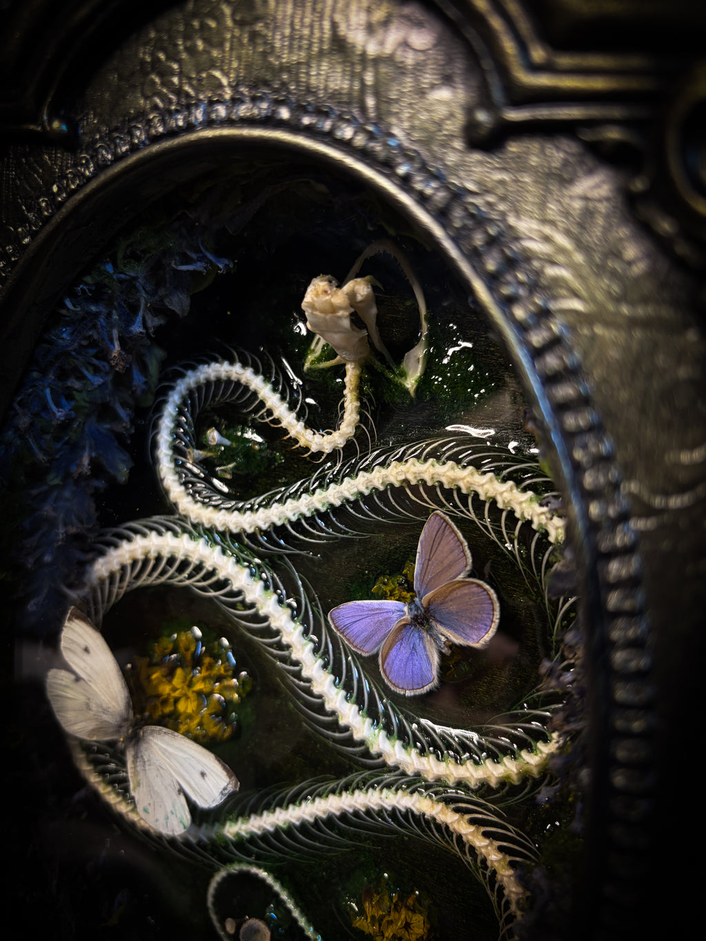 Decorative clock face with intricate designs of a snake, flowers, and butterflies.