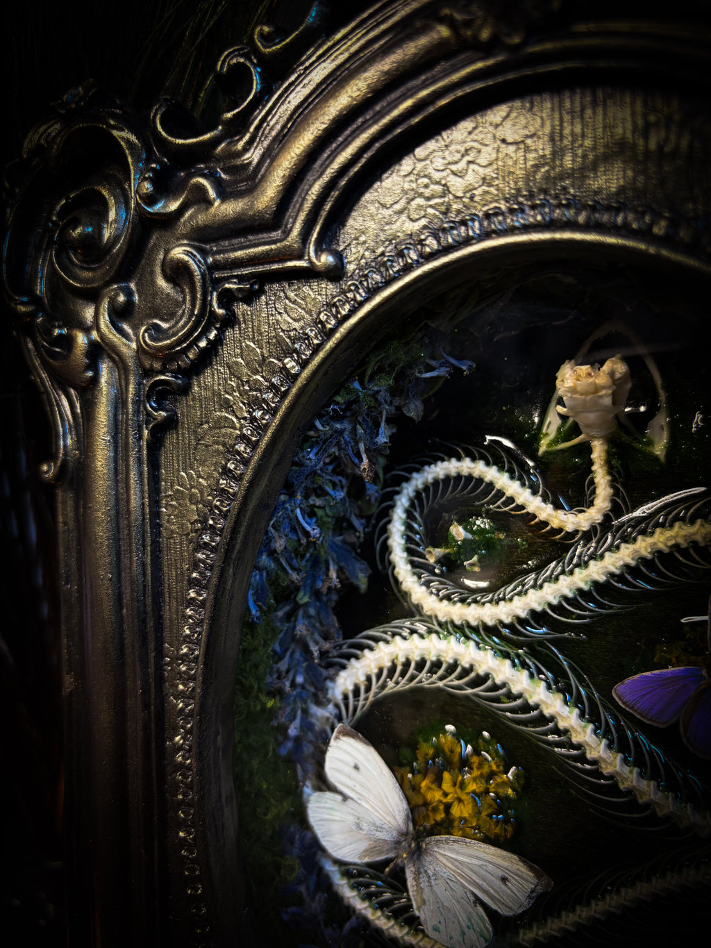 Decorative frame with embroidered elements including a butterfly and floral design.