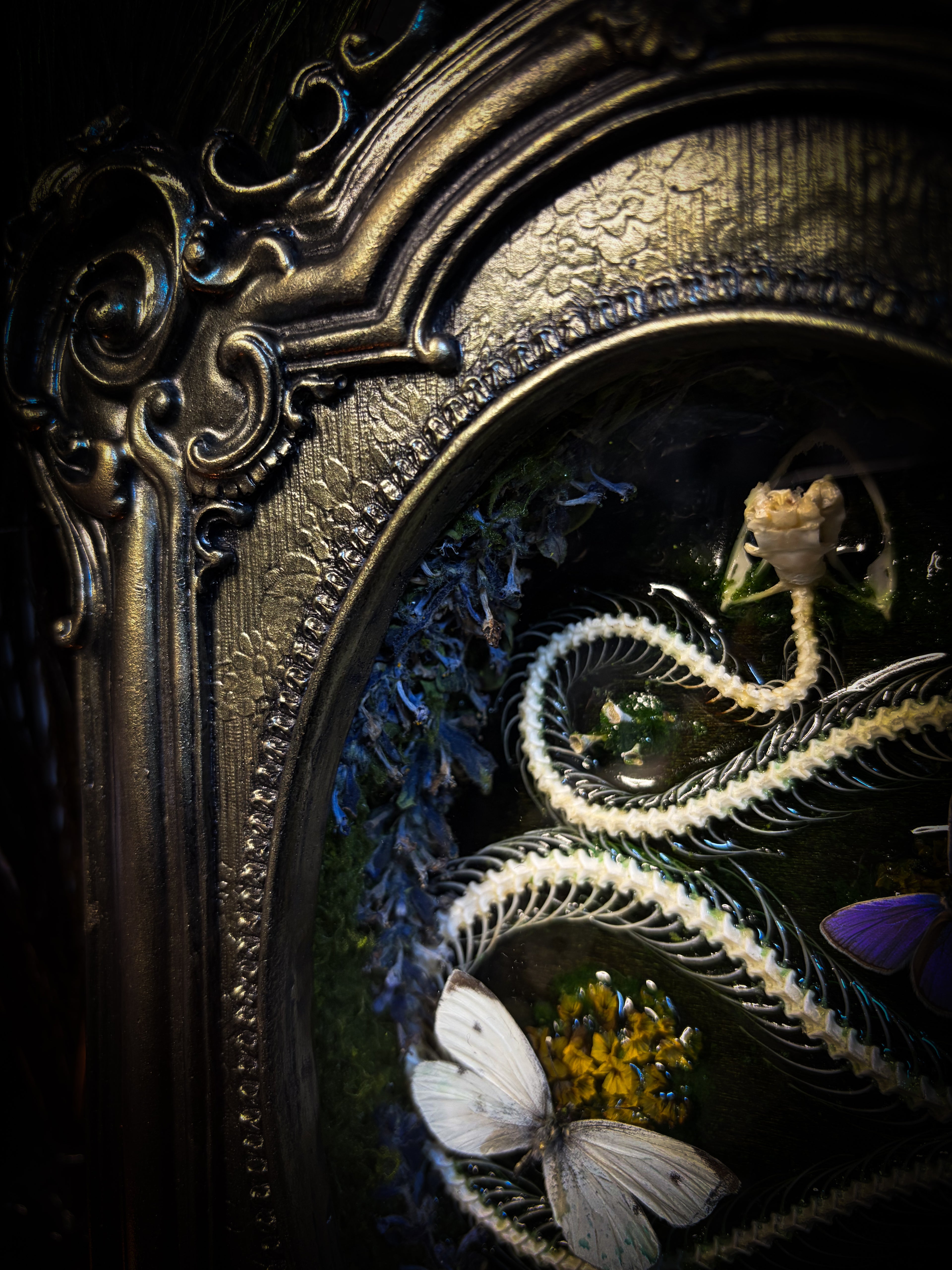 Decorative frame with embroidered elements including a butterfly and floral design.