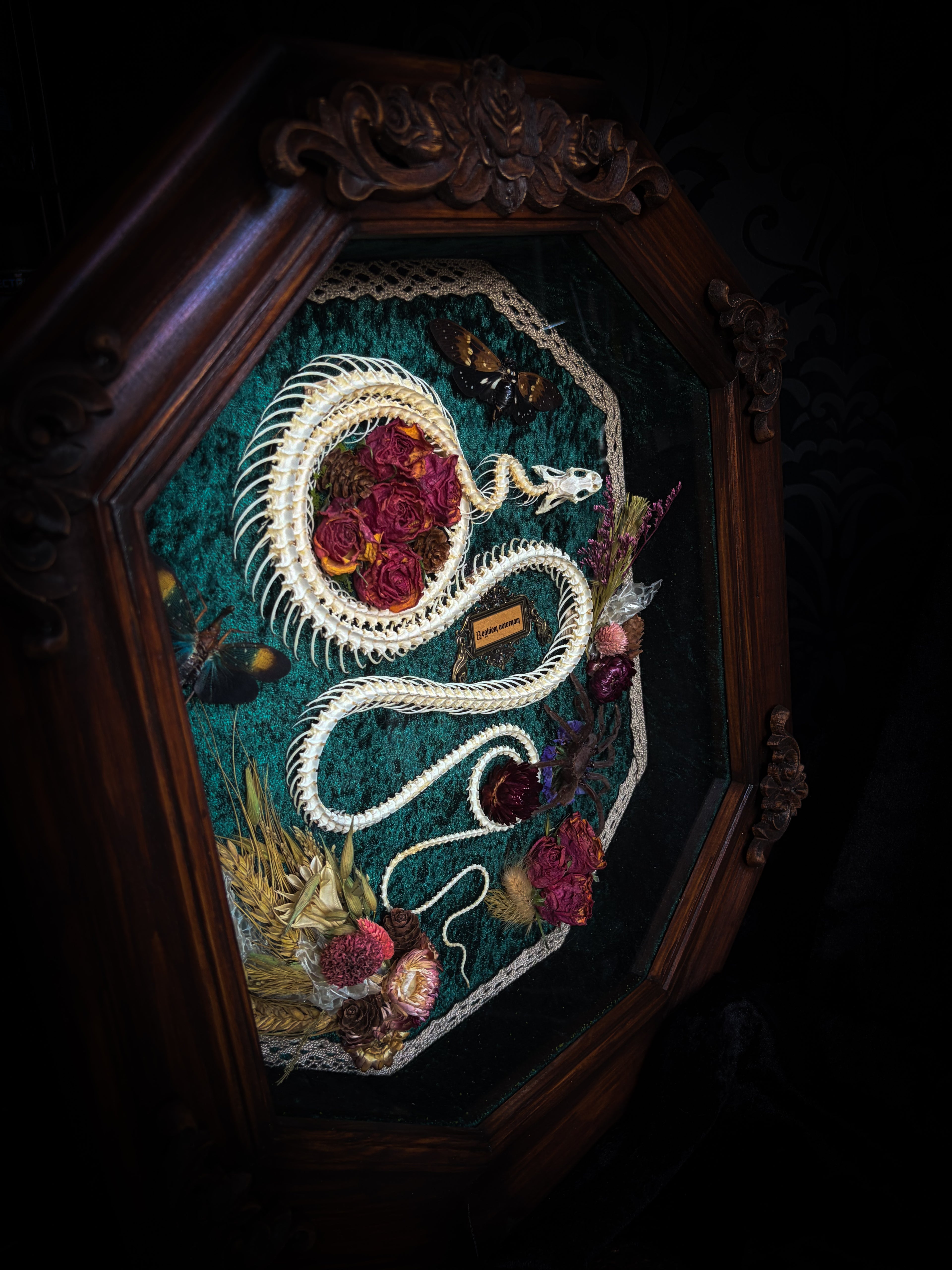 Embroidered artwork of a dragon with flowers and leaves in a wooden frame. Requiem Aeternam — handmade gothic shadowbox with articulated snake skeleton, preserved tarantula, cicadas and florals on deep forest-green velvet | Morbid Oddities

