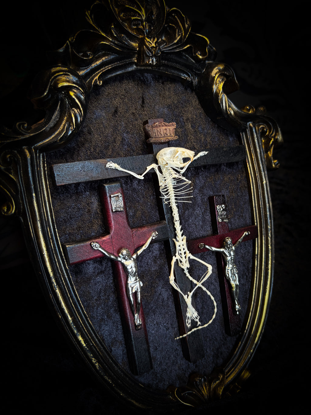 Golgotha | handmade occult relic with real mouse skeleton on three crosses with INRI inscription, cast and painted black and gold frame, black velvet backing | Morbid Oddities
