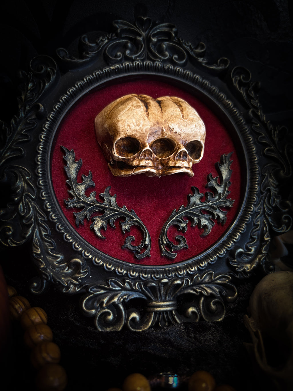 Handmade gothic shadowbox with conjoined skulls, ornate frame, black velvet lining — dark wall decor