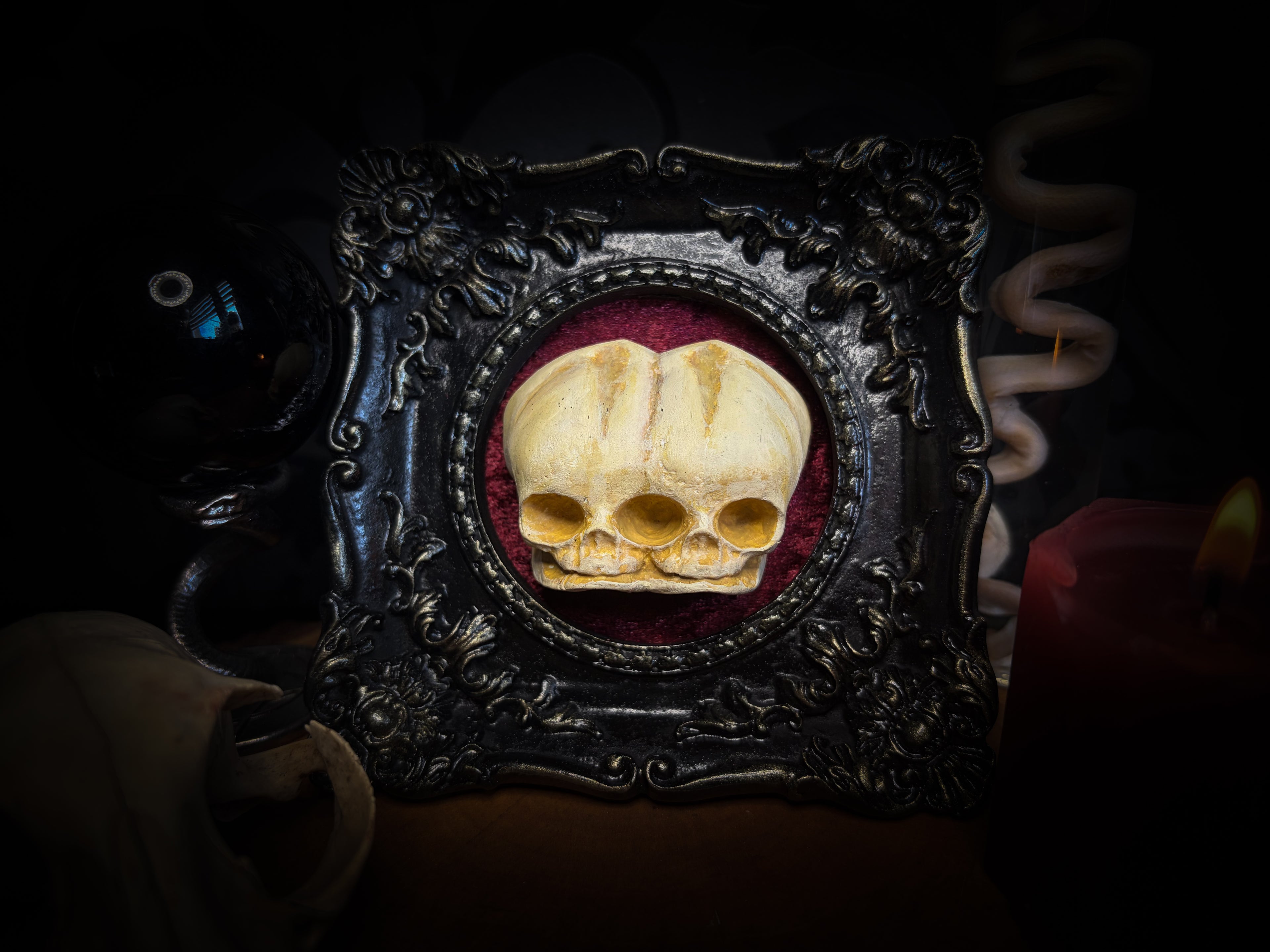 Handmade gothic shadowbox conjoined infant skulls hand-cast ornamental frame black velvet dark wall decor.