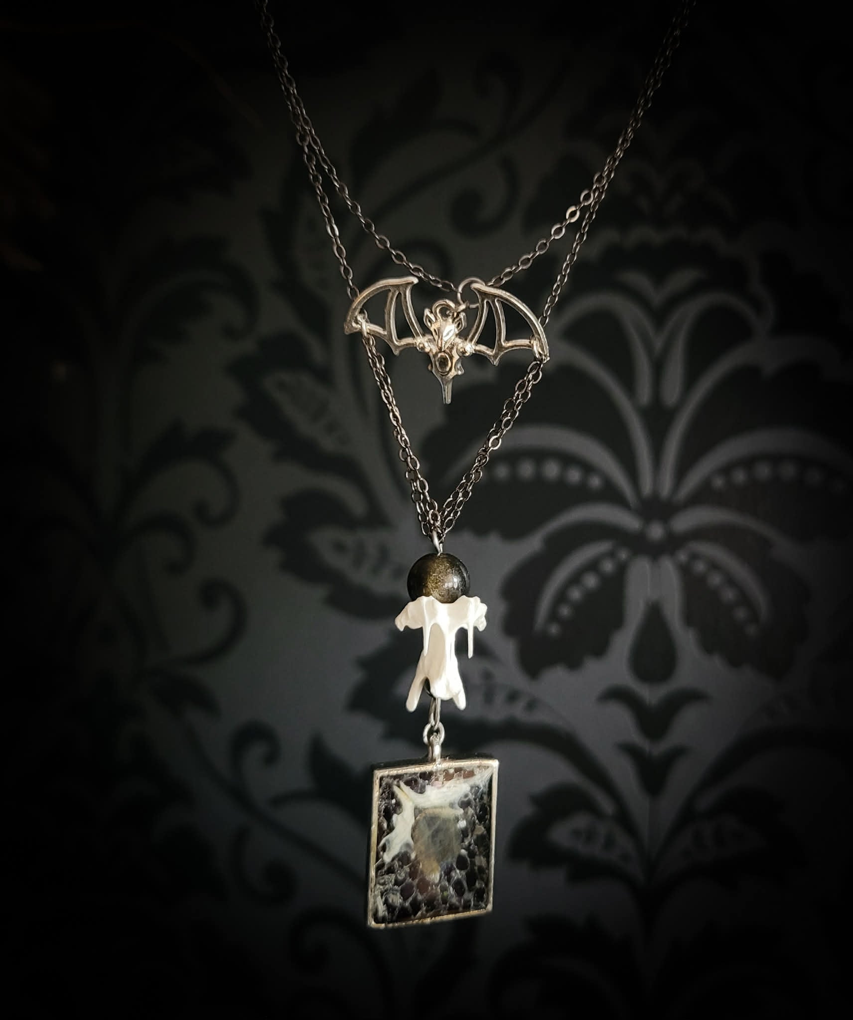 Handmade gothic necklace — labradorite stone and mouse jaw in resin pendant, snake skin background, vertebrae connector, metal bat charm