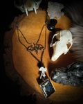 Handmade gothic necklace — labradorite stone and mouse jaw in resin pendant, snake skin background, vertebrae connector, metal bat charm