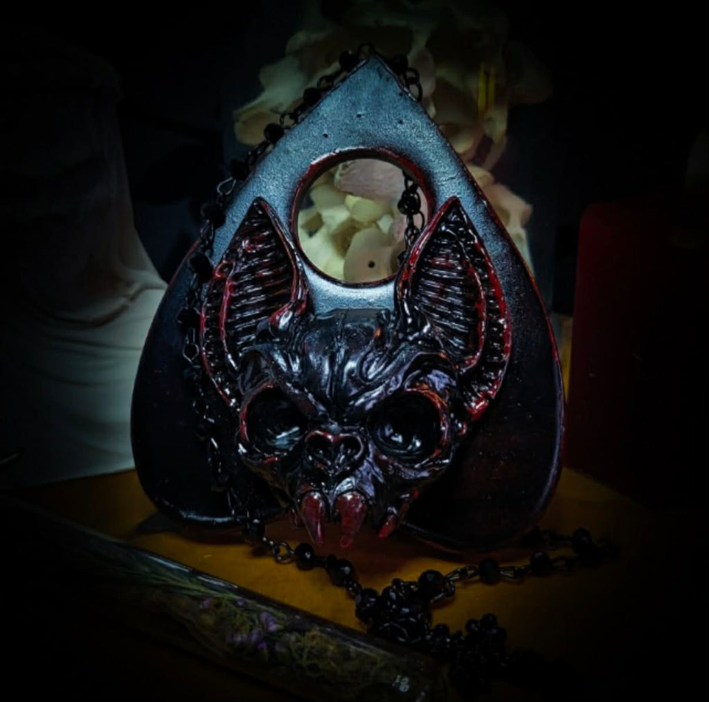 Ouija Planchette — handmade gothic planchette sculpture, made to order. Hand-cast bat and demonic face centerpiece in classic planchette shape, dark bloody finish with deep red accents. Occult altar decor, 8x9cm.